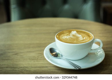 Hot latte art coffee cup on wooden table, vintage and retro style. - Shutterstock ID 329344748