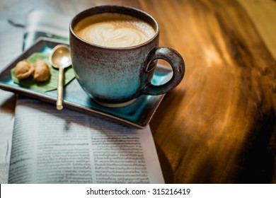 hot latte art coffee with newspaper on wooden table, vintage and retro style. - Powered by Shutterstock