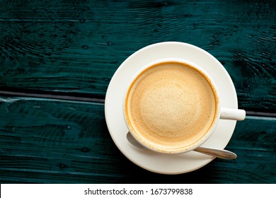 Hot Latte Coffee With Beautiful Smooth Froth In A Classic White Coffee Cup Set Flat Lay Top View On Abstract Pattern Vintage Dark Blue-green Wooden Table Background Texture With Clipping Path