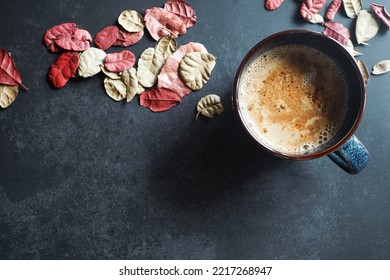 Hot Latte Coffee On The Dark Table With Dry Leaves For Winter Theme