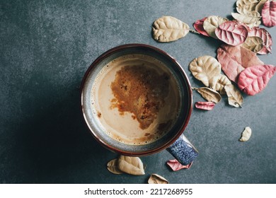 Hot Latte Coffee On The Dark Table With Dry Leaves For Winter Theme