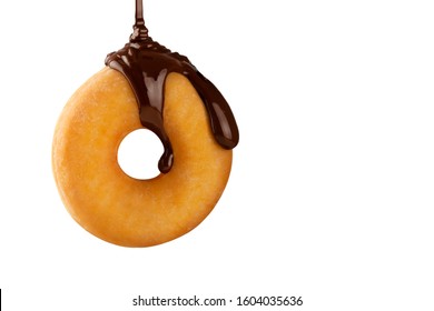 Hot melted chocolate falling fluidly on a delicious donut isolated on white background. Creative pastry. Concept of delicious and fast desserts.