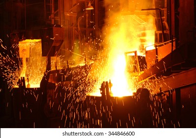 Hot metal pours from a blast furnace with sparks - Shutterstock ID 344846600