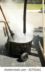 Hot Molten Tar Pours Into A Hot Tar Bucket On A Roof