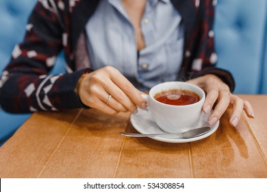 Hot Mug Of Tea With Woman Hands In Retro Woollen Sweater On Wooden Table