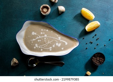 Hot Mushroom Soup With Lime Slice, Black Pepper And Spoon Served In Bowl Top View Soup