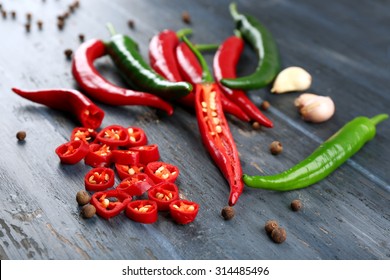Hot peppers with spices on wooden table close up - Shutterstock ID 314485496