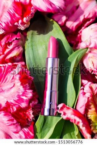 Hot pink lipstick laying in a bed of flowerpetals
