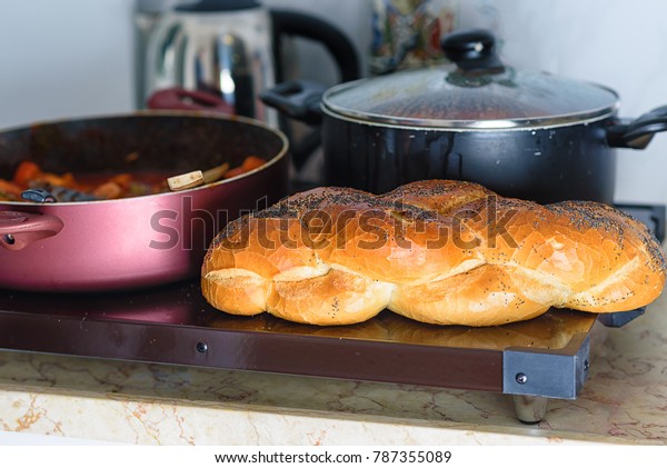Hot plate for the Sabbath, a pot of spicy fish\
cooked with peppers and tomatoes,  pot of cholent or Hamin in\
hebrew and challah-special bread in Jewish cuisine. Traditional\
food for Jewish Shabbat.