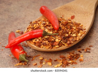 Hot Red Chili Peppers And Red Pepper Flakes On A Wooden Spoon