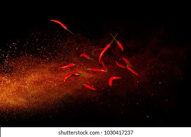 Hot red pepper on a background of ground pepper. Flying composition on black background - Shutterstock ID 1030417237