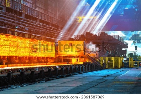 Hot rolled steel production process in the metallurgical industry. Hot metal sheet on a conveyor belt, selective focus. Steel Works, Hot Rolling Mill Shop. 