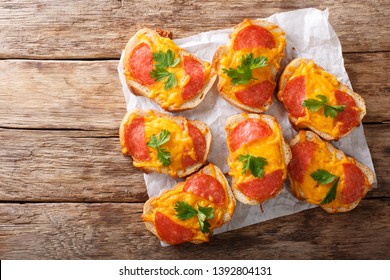 Hot Sandwiches With Sausage And Melted Cheddar Cheese Close-up On The Table. Horizontal Top View From Above
