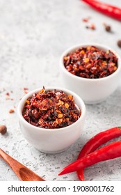 Hot Sauce Of Red Dry Chili Peppers With Soy Oil In A White Bowl Close-up.