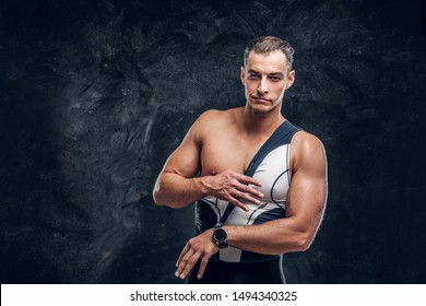 Hot Sexy Fit Man Is Taking Off His Wetsuit In Dark Photo Studio.