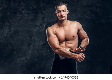 Hot Sexy Fit Man Is Taking Off His Wetsuit In Dark Photo Studio.