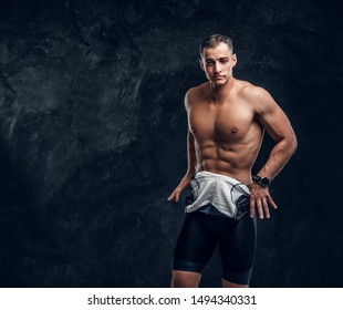 Hot Sexy Fit Man Is Taking Off His Wetsuit In Dark Photo Studio.