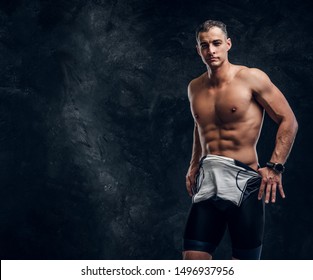 Hot Sexy Fit Man Is Taking Off His Wetsuit In Dark Photo Studio.