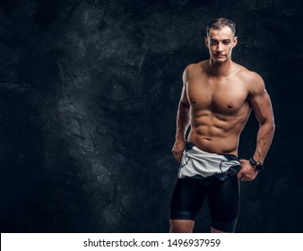 Hot Sexy Fit Man Is Taking Off His Wetsuit In Dark Photo Studio.