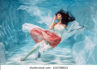 Hot Slim Brunette Woman Posing Under water in beautiful clothes alone in the deep - Powered by Shutterstock