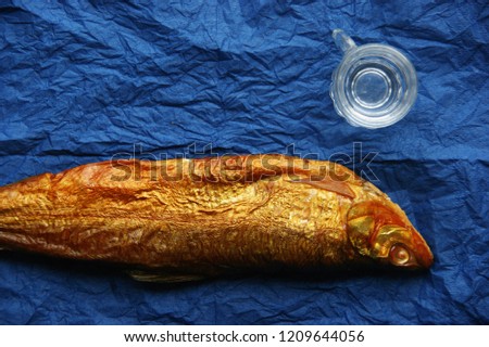 hot smoked whitefish. smoked fish on blue napkins with a glass of vodka