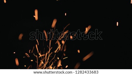 hot sparks from charcoal moving up on black background