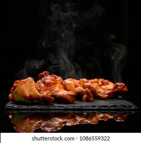 Hot And Spicy Bbq Chicken Wings With Dip And Hot Sauce On Black Stone Plate And Steam Smoke