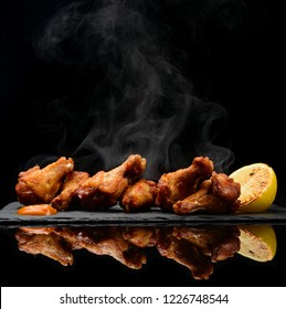 Hot And Spicy Bbq Chicken Wings With Dip And Hot Sauce On Black Stone Plate And Steam Smoke