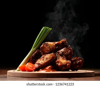 Hot And Spicy Bbq Chicken Wings With Dip And Hot Sauce On Wooden Plate With Steam Smoke And Vegetables