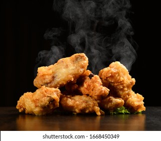 Hot And Spicy Bbq Chicken Wings With With Green Salad Leaf And Steam Smoke On Black Background