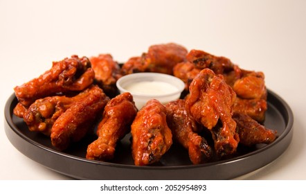 Hot And Spicy Buffalo Chicken Wings Close Up On A White Background With Blue Cheese Dip