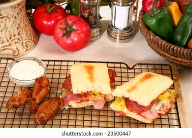 Hot Spicy Buffalo Style Chicken Wings Next To Bowl Of Blue Cheese Dressing And Sub Sandwich.