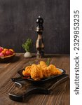 Hot and spicy deep fried breaded chicken wings on shabby serving board