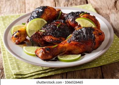 Hot spicy grilled chicken drumstick with lime and green onion close-up on a plate on a table. horizontal