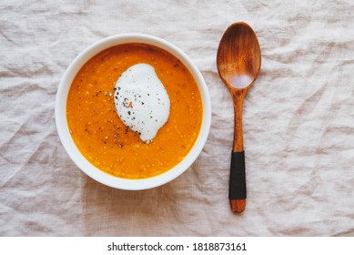 Hot Spicy Pumpkin Soup With Heavy Cream And Pepper In A Bowl On White Background, Top View, Flat Lay Style. Homemade Autumn Food. Popular Thanksgiving Dish.