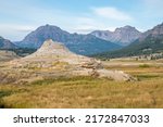 Hot spring cone Soda Butte in Lamar Valley in Yellowstone National Park with valley and mountains in background 