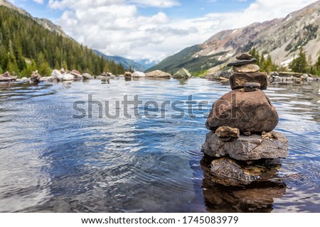 Hot springs pool and rock stack cairn on Conundrum Creek Trail in Aspen, Colorado in 2019 summer with valley view with nobody