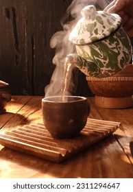 hot steam from a teapot pouring into an earthenware glass

 - Shutterstock ID 2311294647