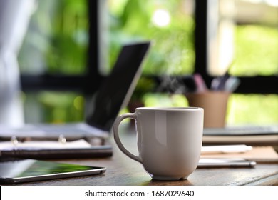 A Hot And Steaming Cup Of Coffee On A Desk With Laptop And Gadget When Work From Home