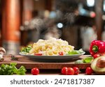 Hot, steaming freshly prepared pasta dish and fresh vegetables near it, Pasta is mediterranean Italian traditional cuisine.