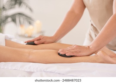 Hot stone massage on womans legs - Powered by Shutterstock