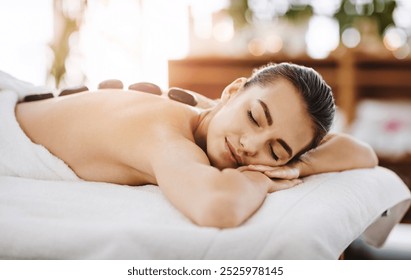 Hot stone massage, relax and woman in spa for massage, peace or stress relief. Beauty, rocks on back of person in salon for body therapy and wellness treatment or healthy detox with eyes closed - Powered by Shutterstock