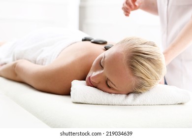 Hot Stone Massage, Swedish Massage .Attractive Blonde Woman In The Office Spa, Relax With A Massage 