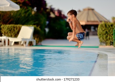 hot summer day, the boy fun dives and swims in the pool