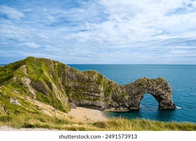 Hot summer day at Durdle Door. Durdle Door limestone arch on the Jurassic Coast in Dorset.Natural landmark.Summer holidays England. Crowded beach, people are spending summer weekend in English seaside - Powered by Shutterstock