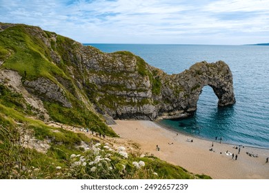 Hot summer day at Durdle Door. Durdle Door limestone arch on the Jurassic Coast in Dorset.Natural landmark.Summer holidays England. Crowded beach, people are spending summer weekend in English seaside - Powered by Shutterstock