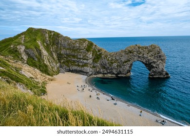 Hot summer day at Durdle Door. Durdle Door limestone arch on the Jurassic Coast in Dorset.Natural landmark.Summer holidays England. Crowded beach, people are spending summer weekend in English seaside - Powered by Shutterstock