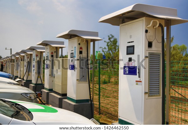 Hot\
summer, outdoor car charging station, charging\
car