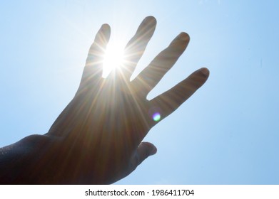 Hot Summer Sunlight Rays Pouring Through Human Hand. Hand Covering Sun Light Heat Temperature. 