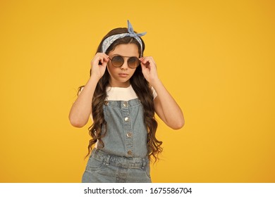 hot and sunny. cheerful little girl yellow wall. retro child long hair. small kid vintage sunglasses. Vacation mode on. Little fashionista. Kids clothes boutique. retro girl. Summer fashion concept.